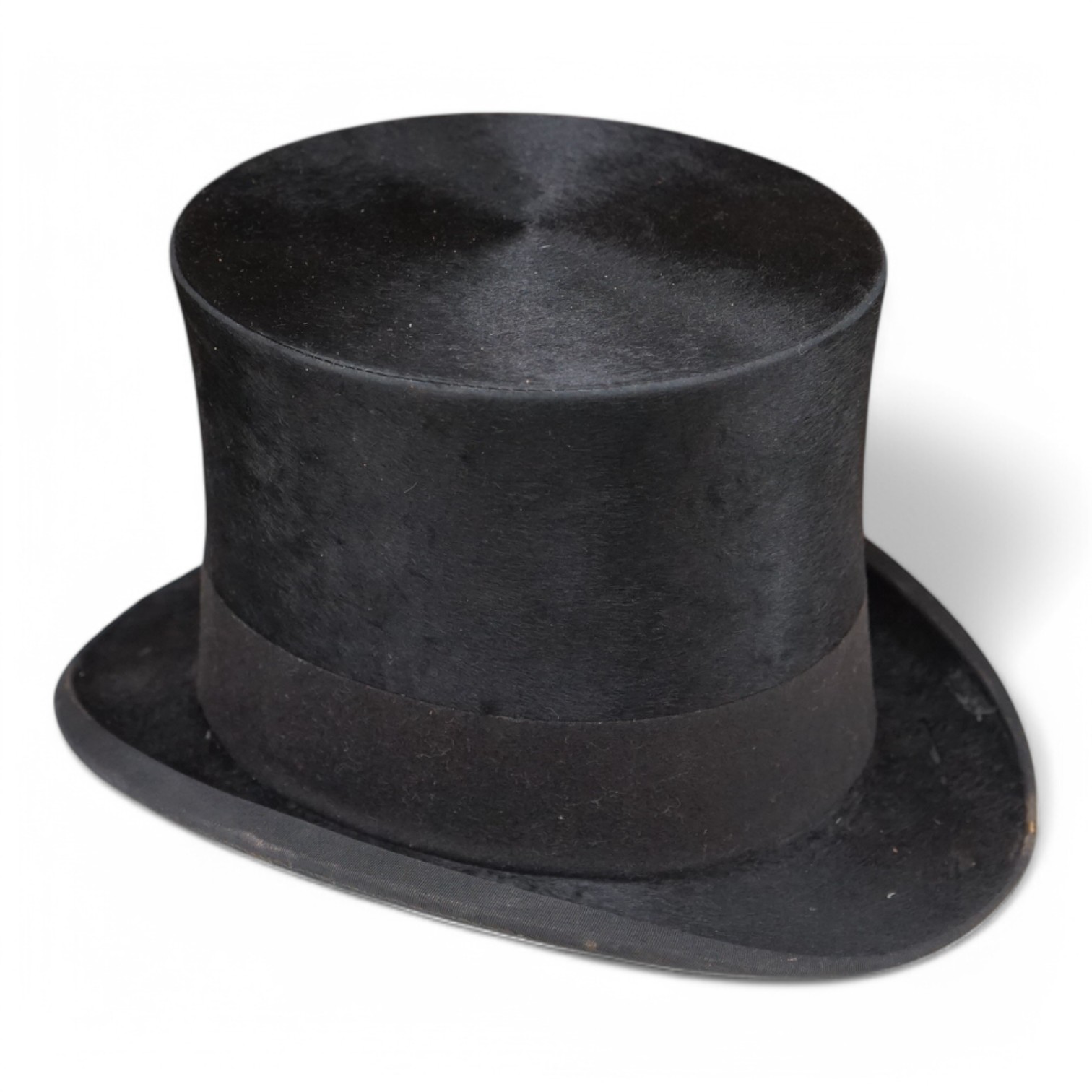 A gentleman’s black silk top hat with a black felt band and, cream silk lining, together with a brown leather case, hat height 17cm. Condition - silk brim worn in various places, leather case very poor